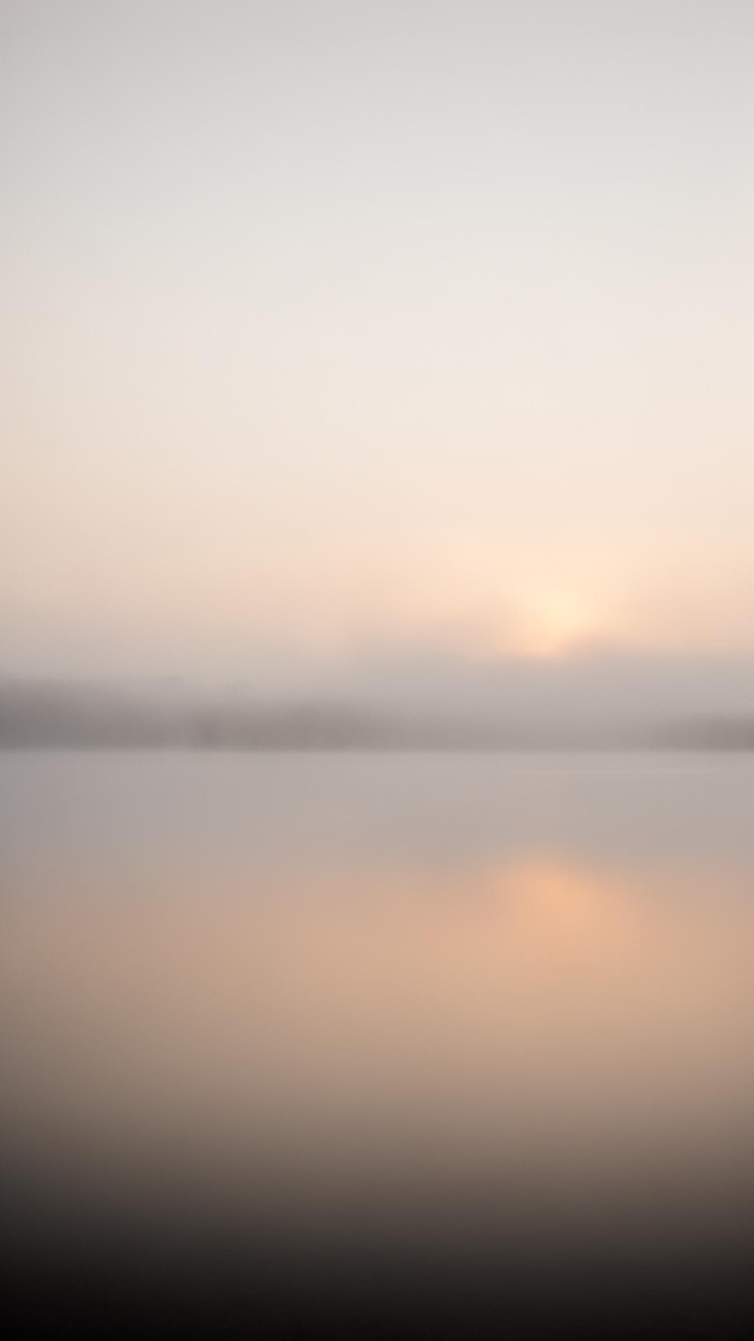 Misty horizon over still water at dawn
